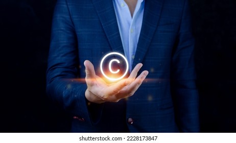 Businessman holding Copyright icon, patents and intellectual property protection law and rights. with symbol of the copyright.copyright symbol from the author. - Shutterstock ID 2228173847