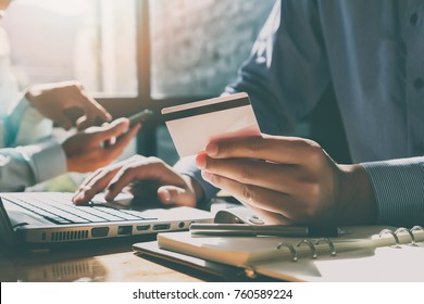 Businessman holding credit card and using laptop. Making payment while online shopping. E-commerce and modern technology concept - Shutterstock ID 760589224
