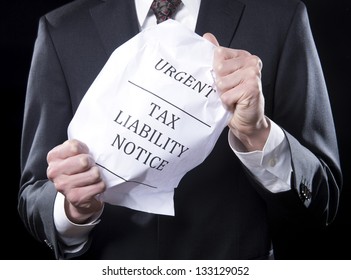 Businessman Holding Crumpled Tax Liability Notice