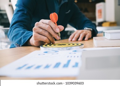 Businessman holding a darts aiming at the target center business goal concept - business targeting, aiming, focus concept,metaphor to target marketing or target arrow concept. - Shutterstock ID 1039039603