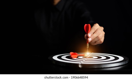 Businessman holding a darts aiming at the target center business success concept . - Shutterstock ID 1906648594
