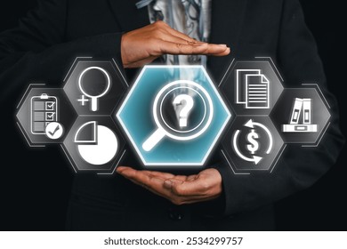 Businessman holding digital icons representing investigation, analysis, and research concepts with a magnifying glass. - Powered by Shutterstock