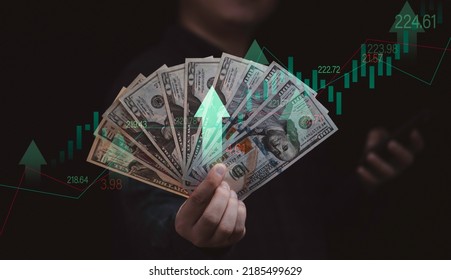 Empresario con billete en dólares con gráfico del mercado de valores y flecha arriba para el concepto de aumento de la inflación y la calificación de interés.