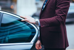 Businessman Holding The Door Of His Limo Showing Off His Watch And Tie Before Getting In