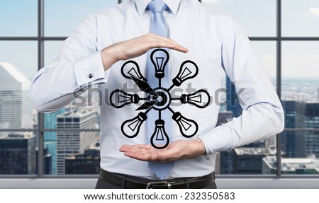Businessman is holding drawn abstract clock. Office background.