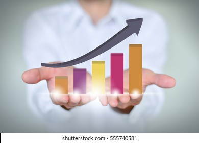 A businessman holding economic growth chart