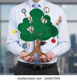 businessman holding education tree in hand - Powered by Shutterstock
