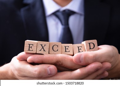 Businessman Holding Exceed Expectations Word In His Hands