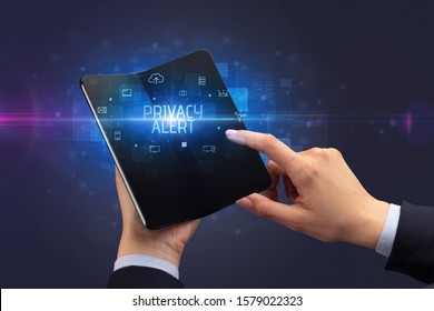 Businessman Holding A Foldable Smartphone With PRIVACY ALERT Inscription, Cyber Security Concept