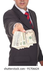 businessman holding and giving away dollar bills (focus is on the hand)