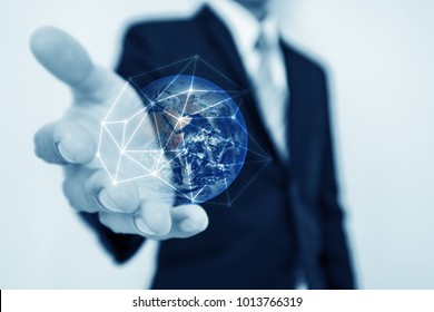 Businessman holding globe hologram with network connection lines. Global business networking, currency exchange and travel around the world concept. Element of this image are furnished by NASA