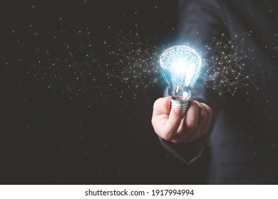 Businessman holding glowing lightbulb with drawing brain and connection line, creative thinking ideas and innovation concept.