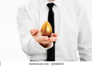 Businessman holding a golden egg concept for wealth, investment and retirement - Powered by Shutterstock