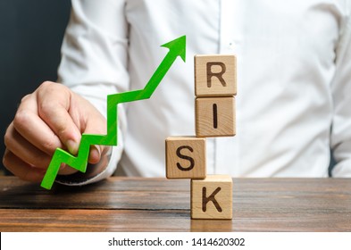 Businessman Holding A Green Up Arrow Near The Word Risk. Improving Business Resilience, Reducing Risks And Costs. Development And Strengthening Of Financial And Economic Systems. Business Strategy.