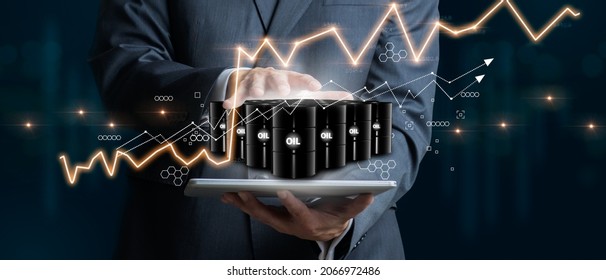 Businessman holding a group of barrels of oil with graphs of the stock market as a concept of raw material. Financial world crisis concept. Down of oil price, market decline. 3D Render - Shutterstock ID 2066972486