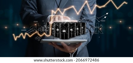 Businessman holding a group of barrels of oil with graphs of the stock market as a concept of raw material. Financial world crisis concept. Down of oil price, market decline. 3D Render