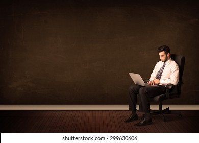 Businessman Holding High Tech Laptop On Brown Background With Copyspace