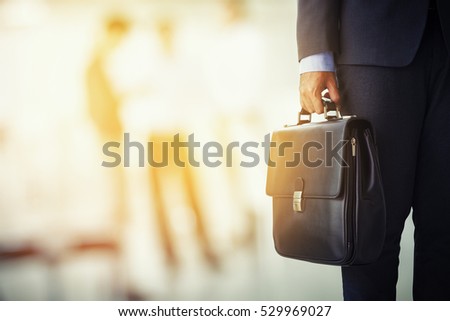 businessman holding his briefcase in office