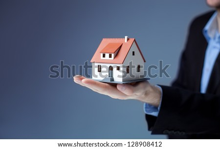 Businessman holding home model. Loan concept