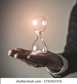 Businessman holding hourglass. time management and time is money concept.