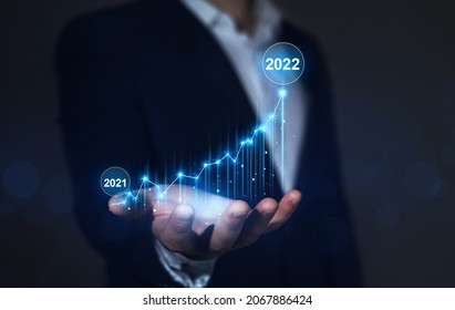 Businessman holding increase arrow graph corporate future growth year 2021 to 2022.   Development to success and motivation. Goals, vision,plan,action and innovation for new year 2022. - Shutterstock ID 2067886424