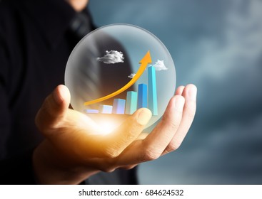 businessman holding increasing graph in crystal ball