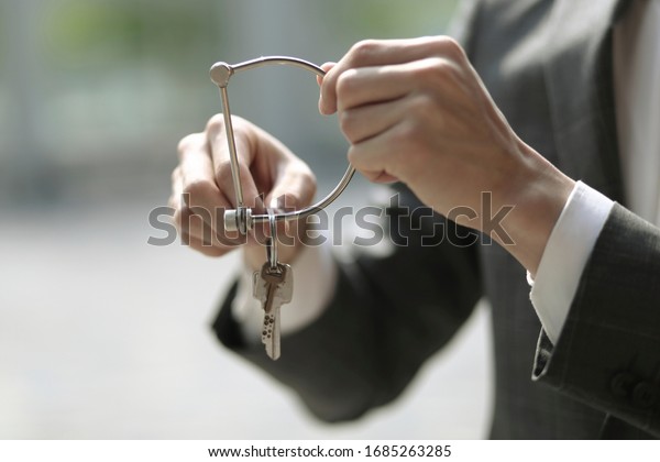 Businessman holding key ring\
and key  