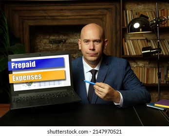 Businessman holding a laptop. Business concept about Prepaid Expenses with phrase on the sheet.
