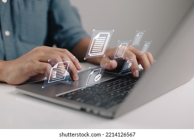Businessman holding a laptop with a document management icon in it while utilizing the data system for business on the internet. - Shutterstock ID 2214126567