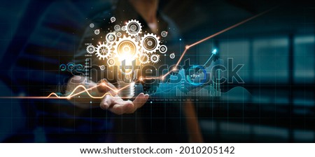 Businessman holding light bulb and cog inside. Creative and inspiration. Media and new idea for business of finance and economic growth. Innovation and technology on network. 