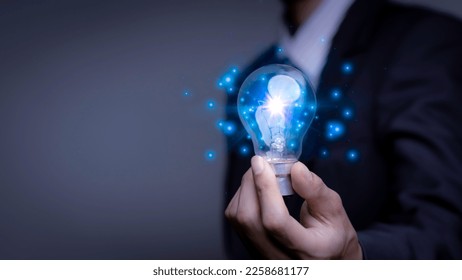 Businessman holding a light bulb, Creative new idea. Innovation, brainstorming, solution and inspiration concepts. imagination, creative thinking problem solving. - Shutterstock ID 2258681177