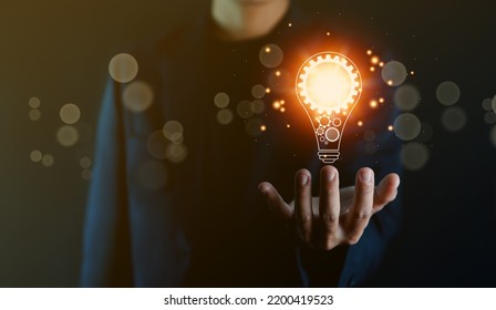 businessman holding a light bulb graphic Digital technology abstract. imagine an idea Creative and innovative. brain to brainstorm ideas in business. Strategies for development, growth, and success - Shutterstock ID 2200419523