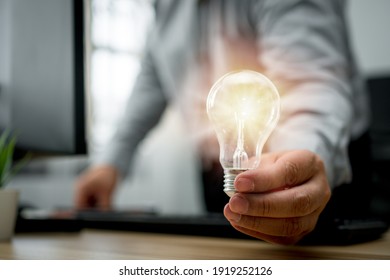 Businessman holding lightbulb and feeling happy by new innovation and ideas for success business panels. Concept of innovation creative technology ideas for Business solution