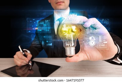 Businessman holding lightbulb with GROWTH HACKING inscription, online security idea concept