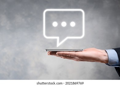 Businessman holding a message icon, bubble talk notification sign in his hands. Chat icon, sms icon, comments icon, speech bubbles. - Shutterstock ID 2021869769