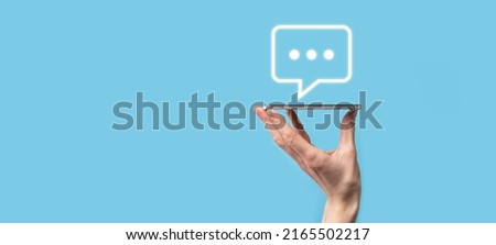Businessman holding a message icon, bubble talk notification sign in his hands. Chat icon, sms icon, comments icon, speech bubbles.
