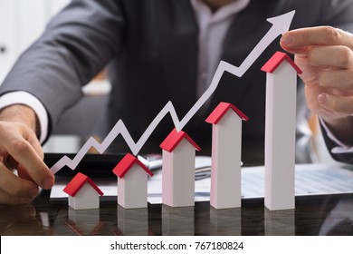 Businessman Holding Paper Graph Over The Increasing House Miniature - Shutterstock ID 767180824