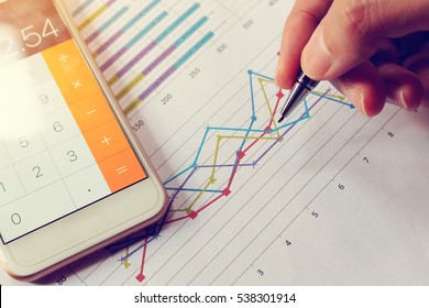 Businessman holding pen and think with cost with calculator in smartphone. - Shutterstock ID 538301914