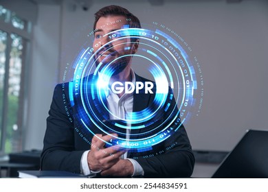 A businessman holding a phone with a holographic GDPR interface in front of him. Modern office background. Concept of data privacy - Powered by Shutterstock