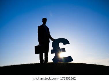 Businessman Holding Pound Currency Symbol - Powered by Shutterstock