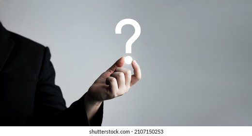 Businessman Holding Question Mark. Concept Of Question Mark And FAQs, Ask Quiestion Online, FAQ Concept, What How And Why, Search Information On Internet. 