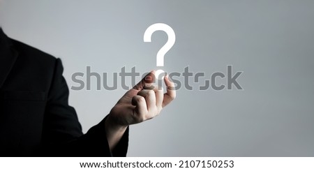 businessman holding question mark. concept of Question mark and FAQs, Ask quiestion online, FAQ concept, what how and why, search information on internet. 
