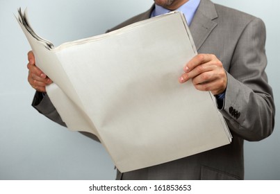 Businessman Holding And Reading A Blank Newspaper With Copy Space