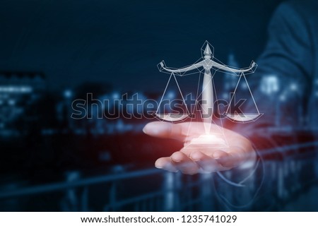 A businessman is holding the scales on his hand at the busy night city centre background. The concept is the legal business affairs principle.