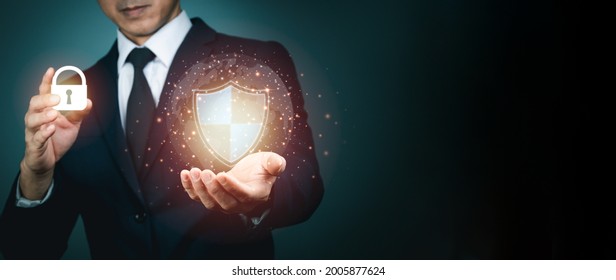 Businessman holding shield protect icon for internet firewall, insurance, or computer virus cleaner. Concept cyber security safe your data.