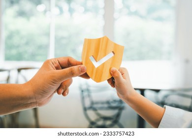 Businessman holding shield protect icon with his child, Security protection and health insurance. The concept of family home, protection, health care day, car insurance and home school education.	 - Powered by Shutterstock