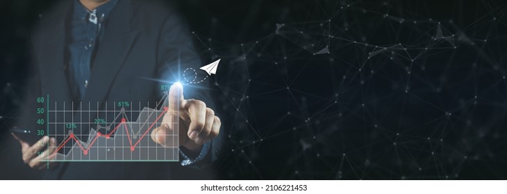 Businessman holding and showing a growing virtual hologram of statistics, graph and chart with arrow up on dark background. Stock market. Business growth, planing and strategy concept  - Shutterstock ID 2106221453