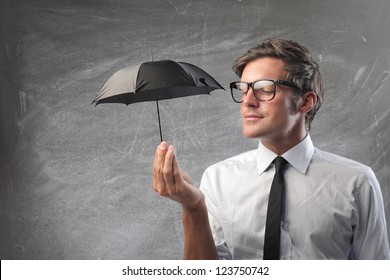 Businessman Holding A Small Black Umbrella