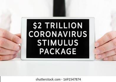 Businessman Holding A Smart Tablet With Sign  $2 Trillion Coronavirus Stimulus Package In Response To The Impact On The Economy And Crisis