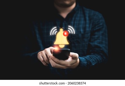 Businessman holding smartphone with virtual yellow bell ringing for application notification alert concept. - Shutterstock ID 2060238374